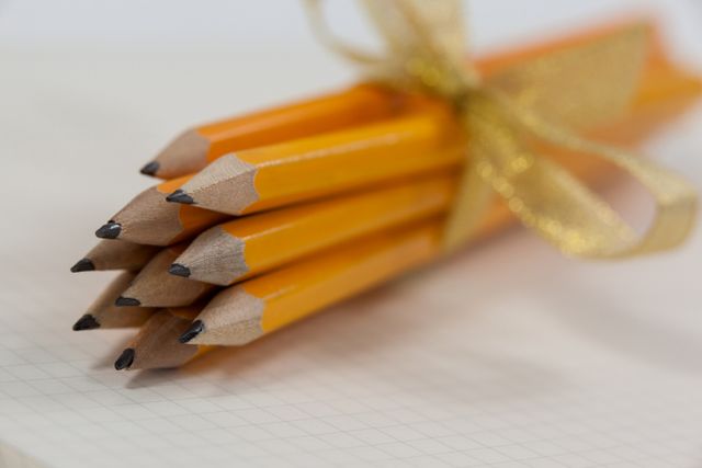 Bunch of pencils wrapped with ribbons on book