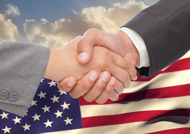 Digital composite image of businesspeople shaking hands against american flag