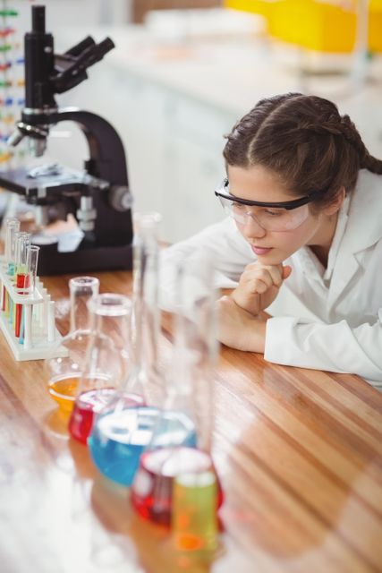 Thoughtful schoolgirl leaning on table in laboratory - Download Free Stock Photos Pikwizard.com