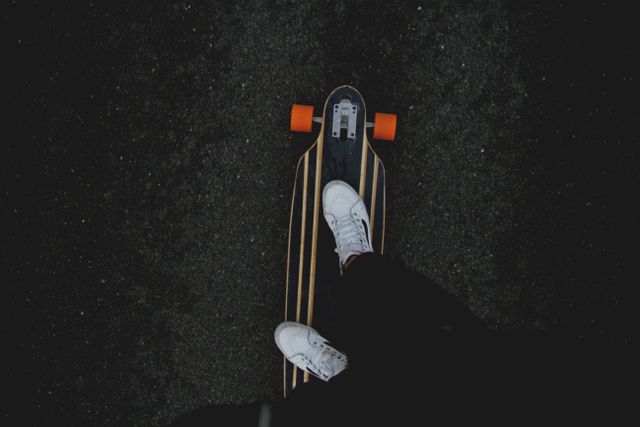 Person Showing White Sneakers and Riding Black Orange and White Skateboard - Download Free Stock Photos Pikwizard.com