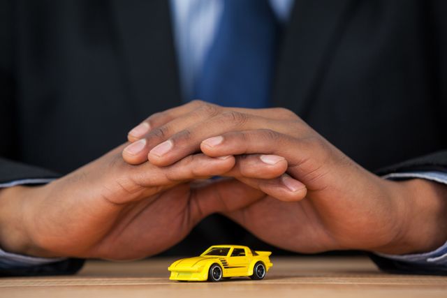 Businessman protecting toy car with hands - Download Free Stock Photos Pikwizard.com