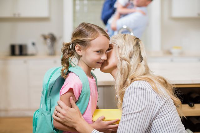 Woman kissing her daughter while going to school - Download Free Stock Photos Pikwizard.com