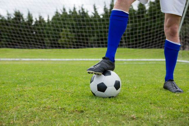 Low section of soccer player with ball on field - Download Free Stock Photos Pikwizard.com