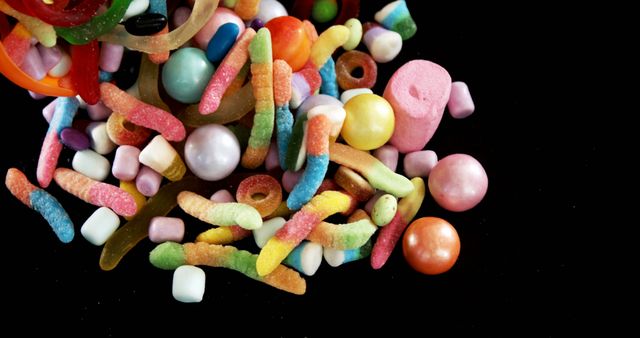 Close up of heap of sweets on black background. Halloween trick or treat and celebration concept.