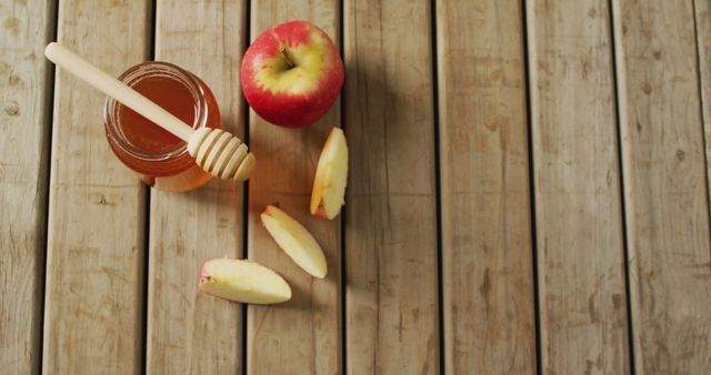 Image of honey in jar and apple and apple slices lying on wooden surface. food, cooking, baking, taste and flavour concept.