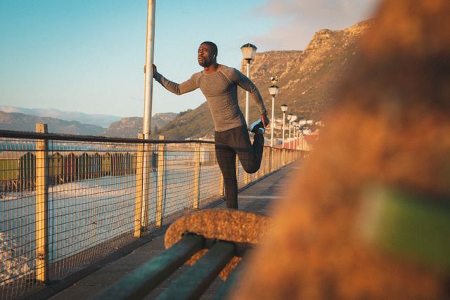 Portrait of african american man exercising, running, stretching on pier at sunset - Download Free Stock Photos Pikwizard.com