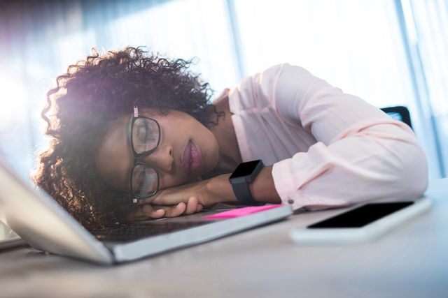 Businesswoman sleeping on her desk at office