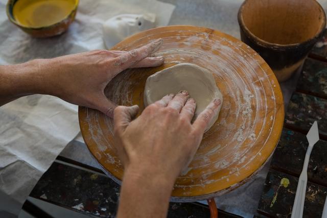 Cropped hand of craftsperson making clay product on pottery wheel - Download Free Stock Photos Pikwizard.com