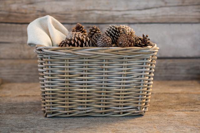 Pine cones in wicker basket on wooden plank - Download Free Stock Photos Pikwizard.com