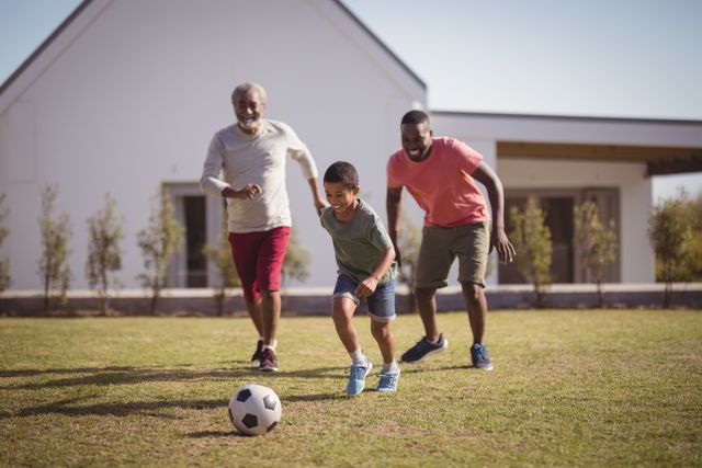 Boy playing football with his father and grandson - Download Free Stock Photos Pikwizard.com