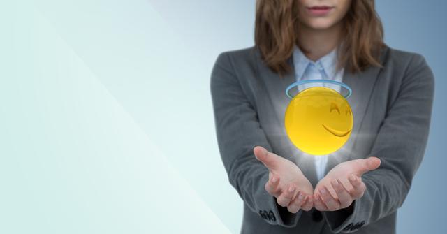 Business woman with hands out and emoji with halo and flare against blue background - Download Free Stock Photos Pikwizard.com
