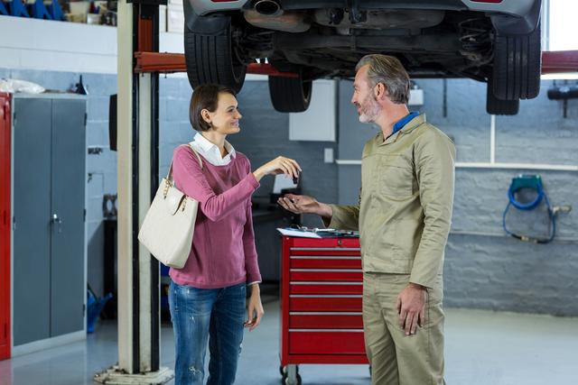 Customer giving her car keys to mechanic - Download Free Stock Photos Pikwizard.com