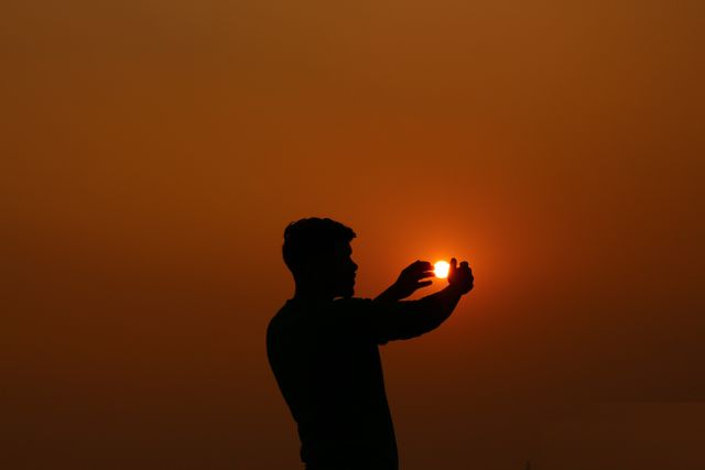 Silhouette of Man Standing Against Orange Sunset Sky - Download Free Stock Photos Pikwizard.com