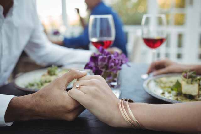 Couple holding hands while having meal - Download Free Stock Photos Pikwizard.com