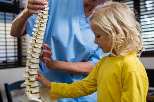 Physiotherapist explaining the spine to girl patient - Download Free Stock Photos Pikwizard.com