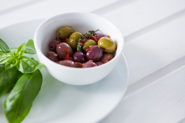 Marinated olives with green leaves in plate - Download Free Stock Photos Pikwizard.com