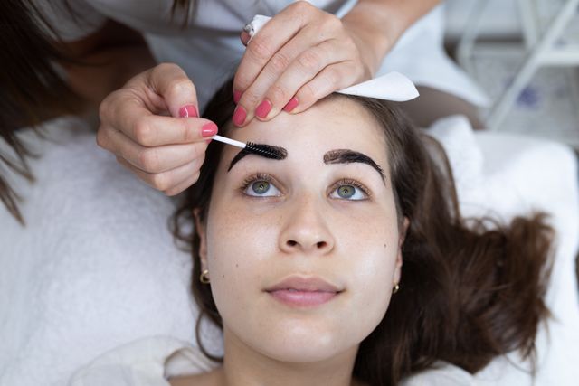 Female caucasian beautician dying eyebrows of a caucasian female customer - Download Free Stock Photos Pikwizard.com