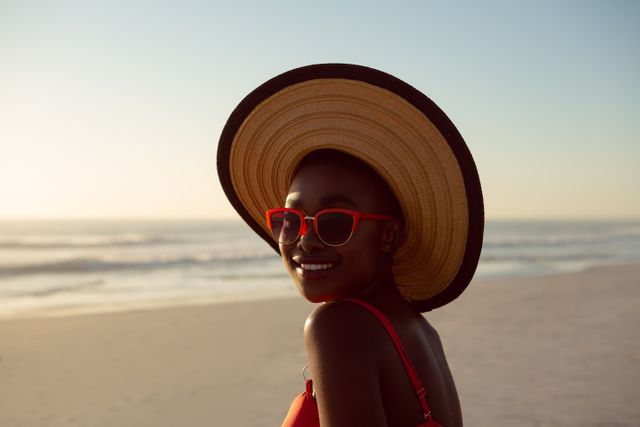 Woman in hat and sunglasses relaxing on the beach - Download Free Stock Photos Pikwizard.com