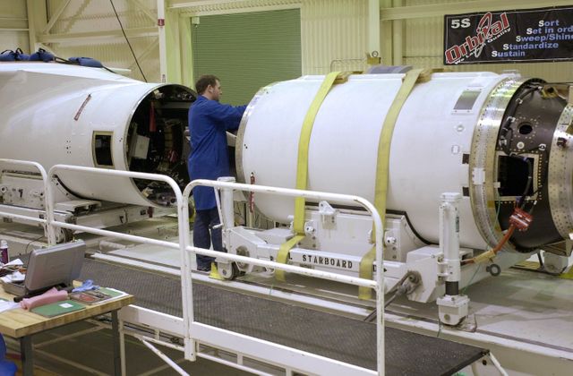 a man working on a large white space ship - Download Free Stock Photos Pikwizard.com