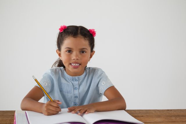 Young girl writing in her book against white background - Download Free Stock Photos Pikwizard.com