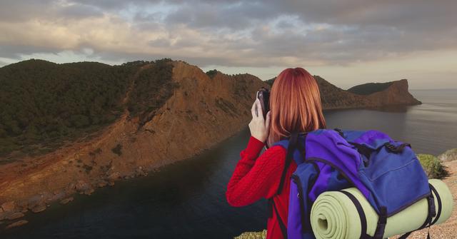 mountain travel, red hair woman taking a photo - Download Free Stock Photos Pikwizard.com