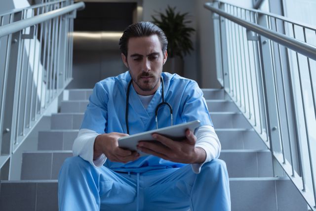 Male surgeon using digital tablet on stairs at hospital - Download Free Stock Photos Pikwizard.com