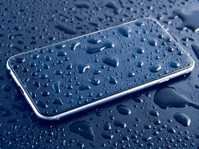 a cell phone with water droplets on it - Download Free Stock Photos Pikwizard.com