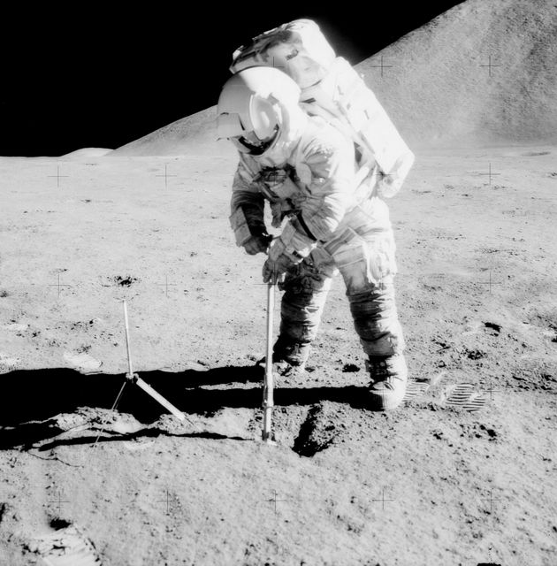 AS15-92-12424 (31 July-2 Aug. 1971) --- Astronaut James B. Irwin, lunar module pilot, uses a scoop in making a trench in the lunar soil during Apollo 15 extravehicular activity (EVA) on the moon. Mount Hadley, which rises approximately 14,765 feet (about 4,500 meters) above the plain, is in the background. Its base is some 14 kilometers (about 8.4 miles) away. The gnomon is at left. While astronauts Irwin, and David R. Scott, commander, descended in the Lunar Module (LM) to explore the moon, astronaut Alfred M. Worden, command module pilot, remained with the Command and Service Modules (CSM) in lunar orbit.