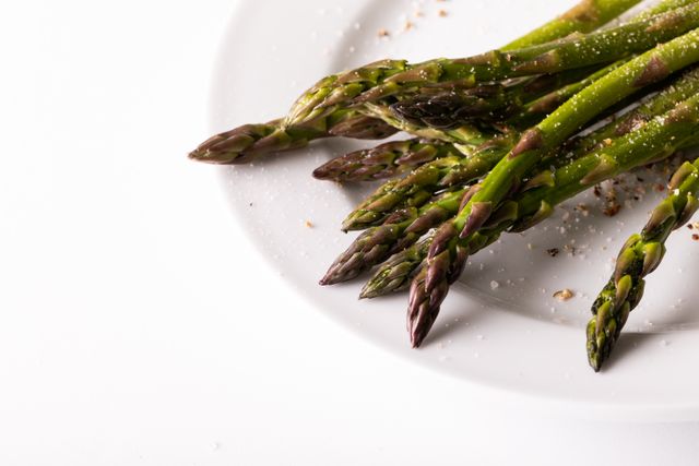 Close-up of asparagus in plate on white background, copy space - Download Free Stock Photos Pikwizard.com