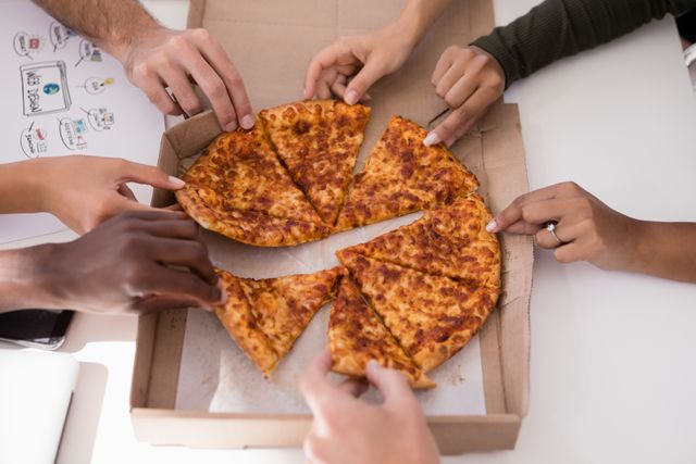 Close-up of executives sharing pizza - Download Free Stock Photos Pikwizard.com