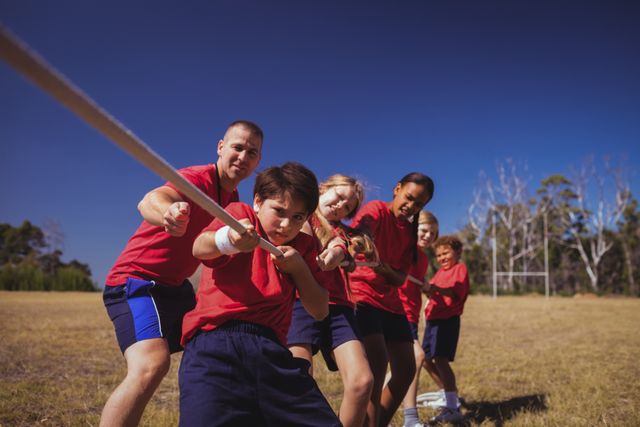 Trainer assisting kids in tug of war during obstacle course training - Download Free Stock Photos Pikwizard.com