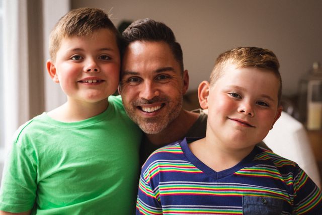 Portrait of caucasian father and two sons smiling together at home - Download Free Stock Photos Pikwizard.com