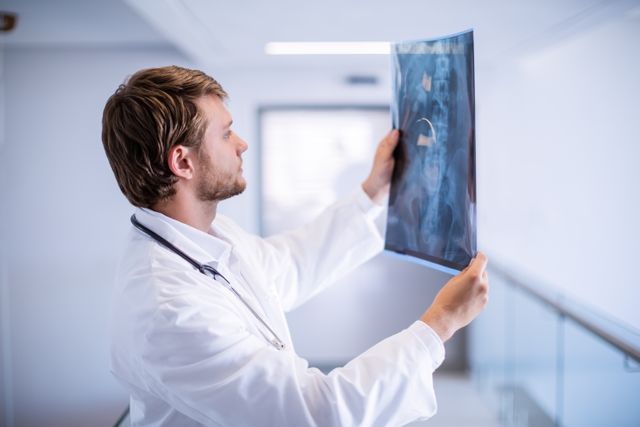 Male doctor examining x-ray in corridor - Download Free Stock Photos Pikwizard.com