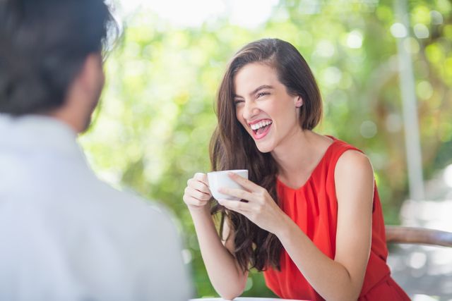 Beautiful woman laughing while having coffee - Download Free Stock Photos Pikwizard.com