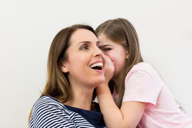 Daughter whispering in her mothers ear - Download Free Stock Photos Pikwizard.com