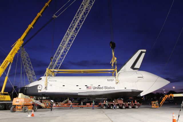 NEW YORK – Space shuttle Enterprise is lowered onto a  specialized truck bed so the prototype spacecraft can be moved into a hangar. The work took place at John F. Kennedy International Airport in New York City. Enterprise, a prototype built to test aspects of the space shuttle design, will be displayed at the Intrepid Sea, Air and Space Museum in New York. Photo credit: NASA/Kim Shiflett