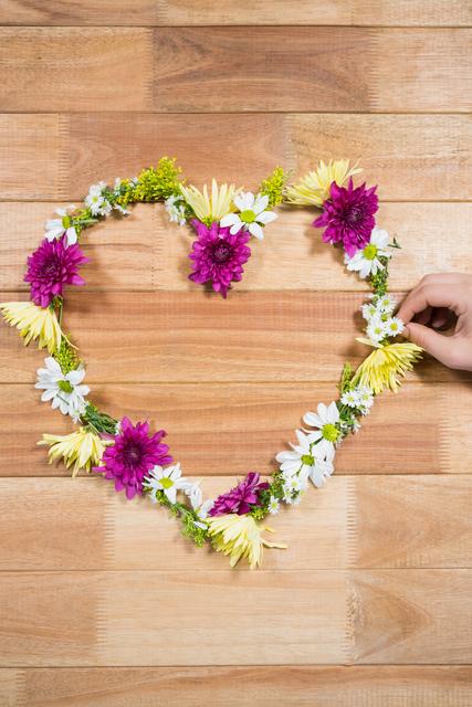 Hand preparing a tropical flower garland arranged in heart shape - Download Free Stock Photos Pikwizard.com