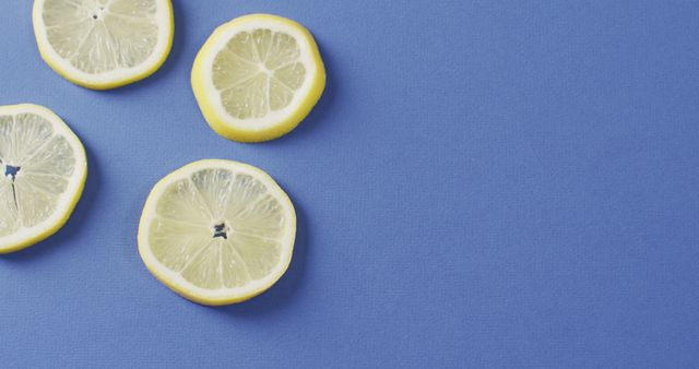 Image of slices of lemon lying on blue background with copy space. food, fruits, citrus, freshens and refreshment concept.