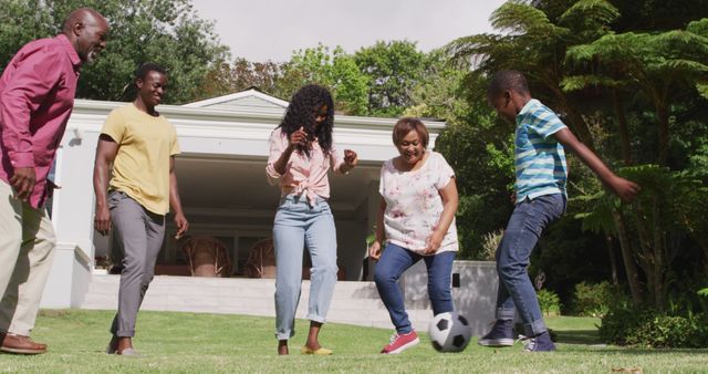 Happy african american multigeneration family playing soccer together in garden. family togetherness and spending quality time outdoors.