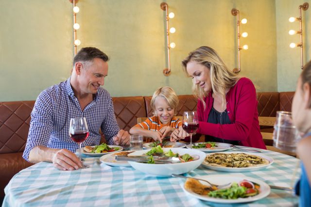 Happy parents with children enjoying dinner - Download Free Stock Photos Pikwizard.com