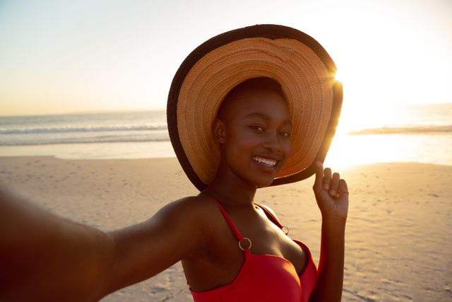 Portrait of happy woman in hat standing on the beach