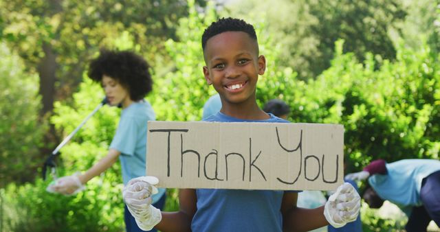Smiling african american son holding thank you sign, clearing up trash outdoors with family - Download Free Stock Photos Pikwizard.com