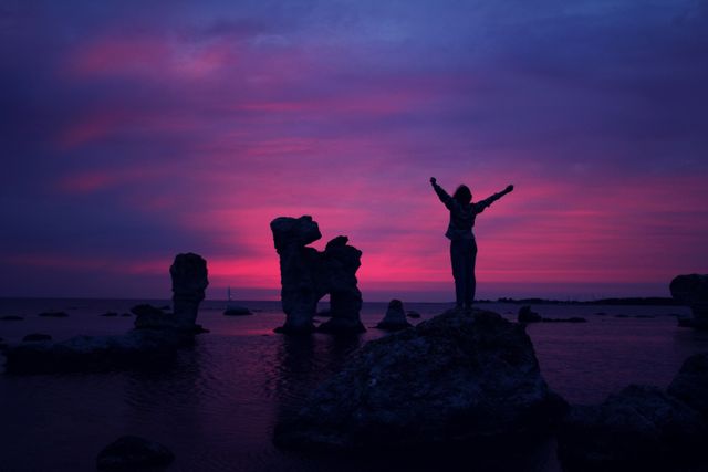 a person standing on rocks at sunset - Download Free Stock Photos Pikwizard.com