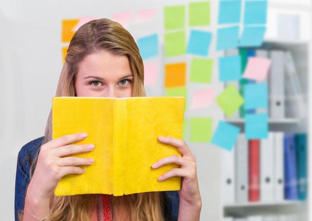 Woman holding a book against sticky notes in background - Download Free Stock Photos Pikwizard.com