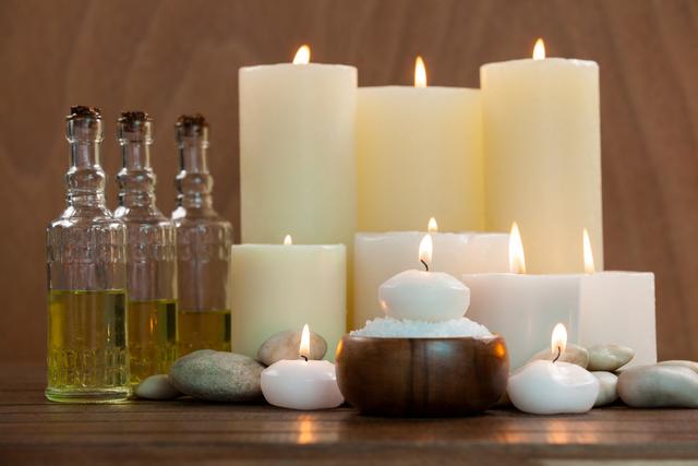 Candles with massage oil bottles and sea salt in wooden bowl - Download Free Stock Photos Pikwizard.com