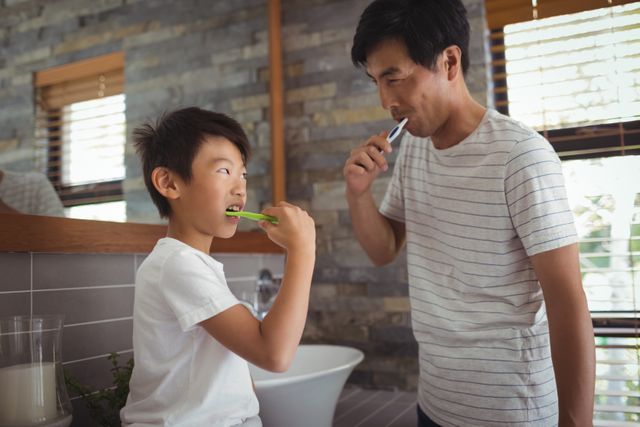Father and son brushing teeth together in bathroom - Download Free Stock Photos Pikwizard.com