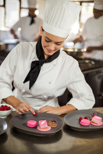 Smiling female chef finishing dessert plates - Download Free Stock Photos Pikwizard.com