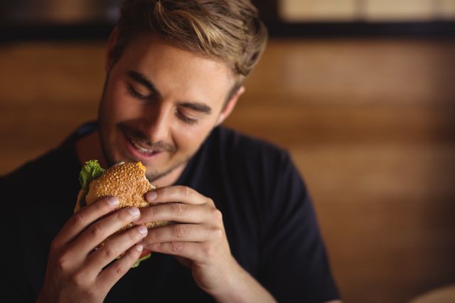 Happy man eating burger - Download Free Stock Photos Pikwizard.com