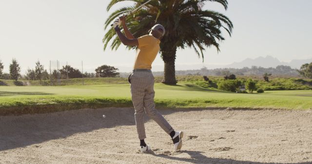 Image of back view of african american man playing golf on golf filed. sporty, active lifestyle and playing golf concept.