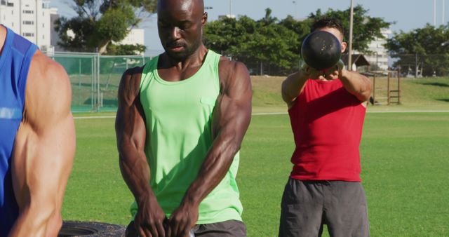 Diverse group of three fit men exercising outdoors, singing kettlebell weights - Download Free Stock Photos Pikwizard.com